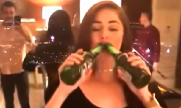 Meisje opent 2 biertjes met haar tanden